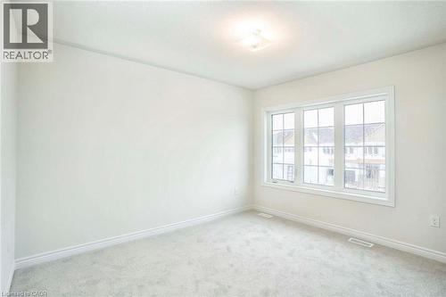 Neutral wall finishes, plush carpet flooring, recessed lighting, and a multi-pane window - 525 Red Elm Road, Shelburne, ON - Indoor Photo Showing Other Room