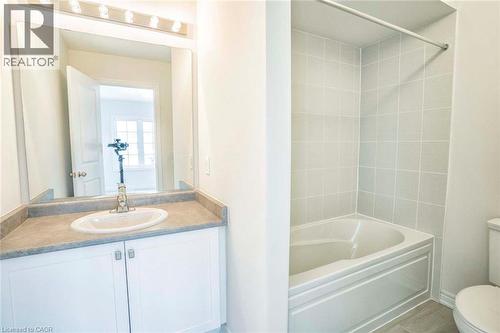 Vanity with a white oval sink, stone-finish countertop, and white cabinetry - 525 Red Elm Road, Shelburne, ON - Indoor Photo Showing Bathroom