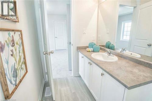 Vanity with a white undermount sink, dual-handle faucet, and white cabinetry with silver-tone hardware - 525 Red Elm Road, Shelburne, ON - Indoor Photo Showing Bathroom