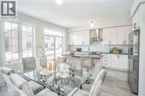 Open-concept kitchen with white shaker cabinetry, stainless steel appliances, and a central island with bar seating - 525 Red Elm Road, Shelburne, ON - Indoor