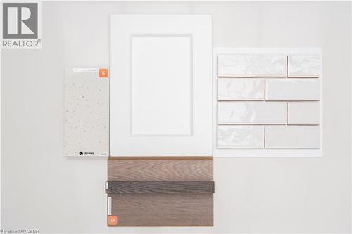 White flat panel cabinetry, light speckled countertop material, white rectangular subway tile, and wood-finish flooring samples - 443 Benninger Drive, Kitchener, ON - Other