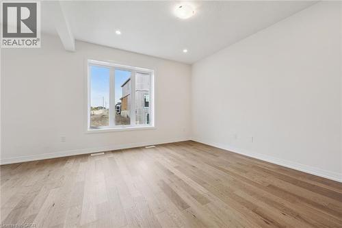Hardwood flooring, recessed lighting, large window with white trim, white walls, and a ceiling light fixture - 451 Benninger Street, Kitchener, ON 