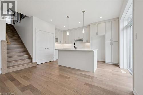 Open-concept kitchen featuring an island with a sink, white cabinetry, and recessed lighting - 451 Benninger Street, Kitchener, ON 