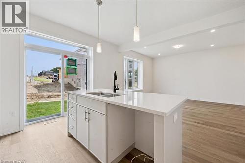 Kitchen island with dual basin sink, white cabinetry, and a light-toned countertop - 451 Benninger Street, Kitchener, ON 