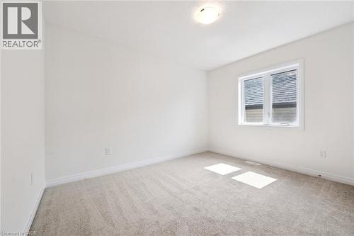 Neutral-toned carpeting, white walls, and a ceiling-mounted light fixture - 451 Benninger Street, Kitchener, ON 