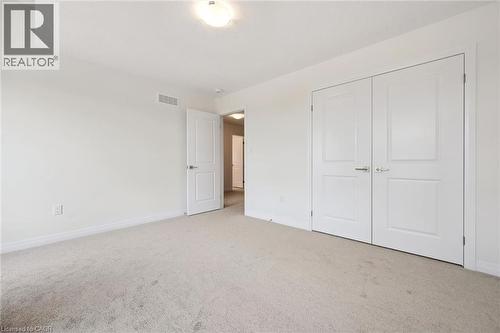 Wall-to-wall carpeting, white interior doors, and a flush mount ceiling light fixture - 451 Benninger Street, Kitchener, ON 