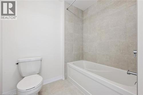 Full-size bathtub with surrounding tile, an integrated shower, and a chrome shower rod - 451 Benninger Street, Kitchener, ON 