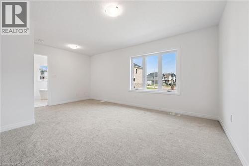 Spacious room with plush carpeting, neutral wall finishes, and abundant natural light through a large multi-pane window - 451 Benninger Street, Kitchener, ON 