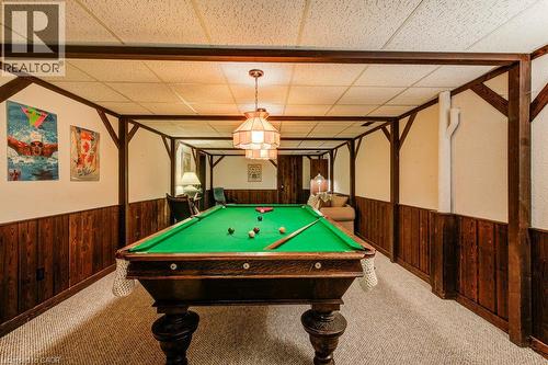 Recreation room featuring a paneled wood accent wall, exposed wood beams, and a drop ceiling with recessed lighting - 97 Somerset Crescent, Waterloo, ON - Indoor Photo Showing Other Room