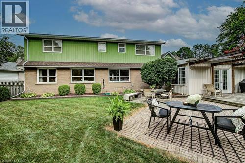 Expansive backyard featuring a lush lawn, two distinct patio areas, and mature landscaping - 97 Somerset Crescent, Waterloo, ON - Outdoor