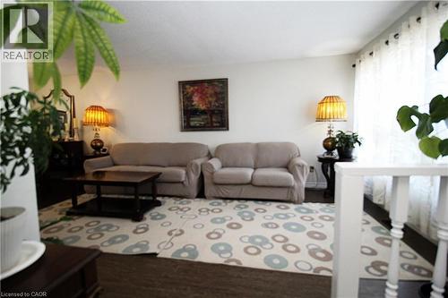 Dark wood-finish flooring with a light-toned area rug - 35 Garden Crescent, Hamilton, ON - Indoor Photo Showing Living Room