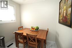 White-framed window with blinds, light-colored walls, white baseboards, and patterned floor tile - 