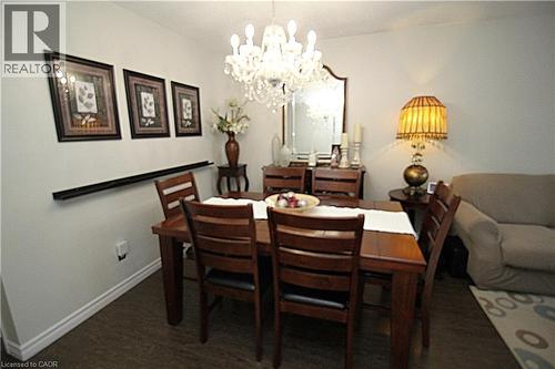 Dining area featuring wood-finish flooring, a crystal chandelier, and a decorative wall shelf - 35 Garden Crescent, Hamilton, ON - Indoor Photo Showing Dining Room