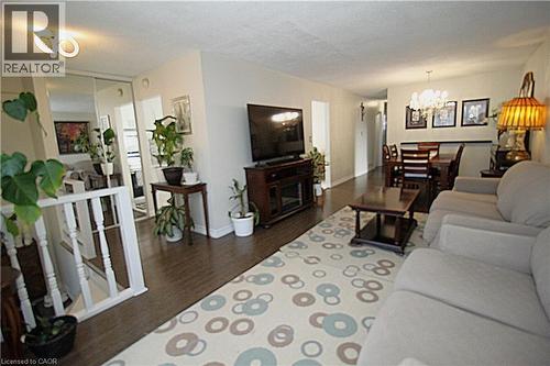 Hardwood-finish flooring, recessed lighting, white painted railing, mirrored closet doors, and chandelier lighting - 35 Garden Crescent, Hamilton, ON - Indoor Photo Showing Living Room