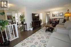 Hardwood-finish flooring, recessed lighting, white painted railing, mirrored closet doors, and chandelier lighting - 