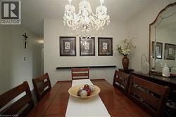 Crystal chandelier illuminating a dining area with a wood-finish table and slat-back chairs - 