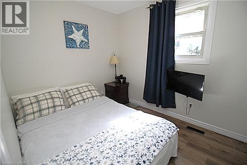 Wood-finish flooring with white trim and a window with white casing - 35 Garden Crescent, Hamilton, ON - Indoor Photo Showing Bedroom