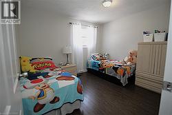 Dark wood-finish flooring, white walls, and a ceiling-mounted light fixture - 