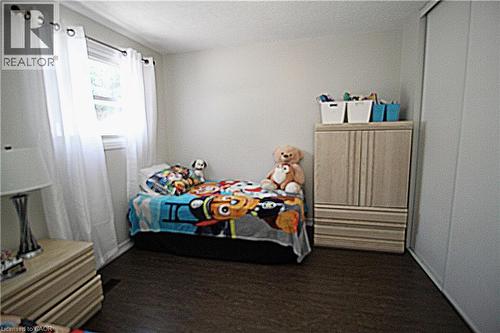 Wood-finish flooring with a white wall finish and a built-in sliding closet - 35 Garden Crescent, Hamilton, ON - Indoor Photo Showing Bedroom