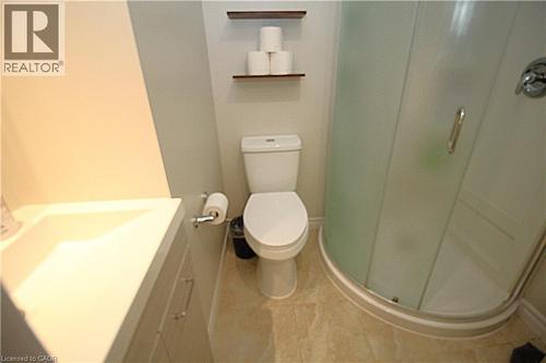 Built-in corner shower with frosted glass enclosure, white vanity with integrated sink, and two wall-mounted shelving units - 35 Garden Crescent, Hamilton, ON - Indoor Photo Showing Bathroom