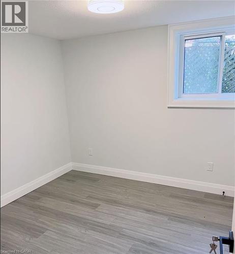 Neutral tone walls with white trim, wood-finish flooring, and a single window - 81 Second Avenue Unit# B, Kitchener, ON - Indoor Photo Showing Other Room