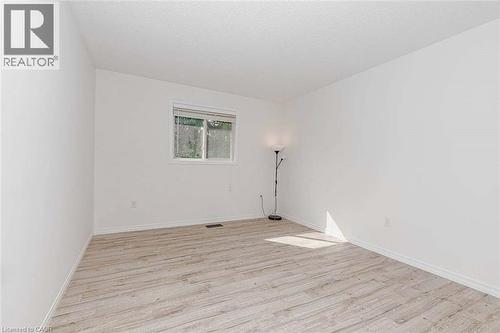 White walls featuring a single window and wood-finish flooring - 47 Queensway Drive, Strathroy, ON - Indoor Photo Showing Other Room