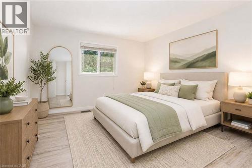 Light-toned wood-finish flooring, neutral wall tones, and a window with exterior foliage - 47 Queensway Drive, Strathroy, ON - Indoor Photo Showing Bedroom