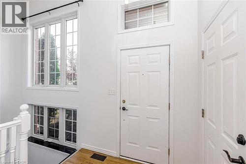 Hardwood-finish flooring, white paneled doors, and multiple windows with grid patterns - 47 Queensway Drive, Strathroy, ON - Indoor Photo Showing Other Room