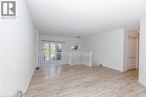 Open-concept room featuring light wood-finish flooring, white walls, and a white railing - 47 Queensway Drive, Strathroy, ON - Indoor Photo Showing Other Room