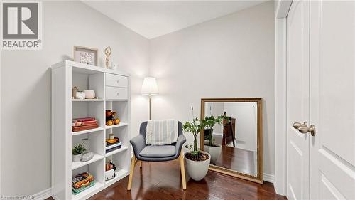 Rich wood-finish flooring, white paneled doors with bronze hardware, and a white cube storage unit - 173 Raymond Road, Ancaster, ON - Indoor Photo Showing Other Room