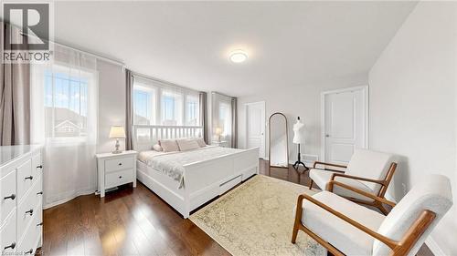 Bright room featuring multiple windows, dark wood-finish flooring, and white walls - 173 Raymond Road, Ancaster, ON - Indoor Photo Showing Bedroom