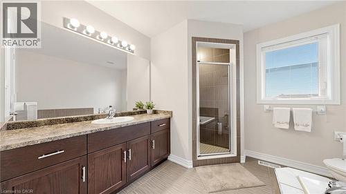 Dark wood-finish vanity with ample storage, a single basin sink, and an expansive mirror - 173 Raymond Road, Ancaster, ON - Indoor Photo Showing Bathroom