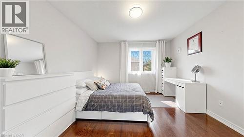Wood-finish flooring, white walls, white window treatments, and a white ceiling-mounted light fixture - 173 Raymond Road, Ancaster, ON - Indoor Photo Showing Bedroom