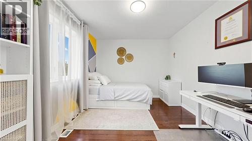 Hardwood flooring, white walls, built-in shelving, large window, and overhead lighting - 173 Raymond Road, Ancaster, ON - Indoor Photo Showing Bedroom