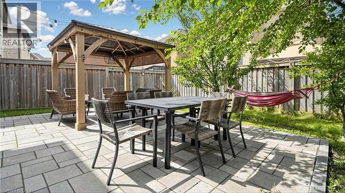 Paved patio with a wood gazebo, surrounded by a wood fence, and mature trees - 173 Raymond Road, Ancaster, ON - Outdoor With Deck Patio Veranda
