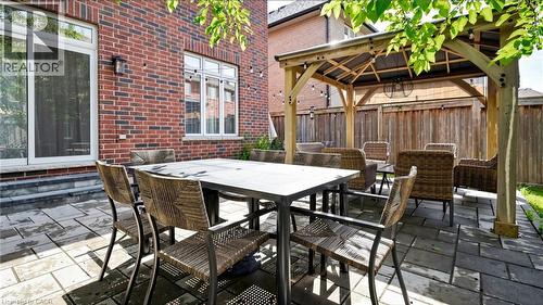 Expansive brick exterior with a sliding glass door and multiple windows - 173 Raymond Road, Ancaster, ON - Outdoor With Deck Patio Veranda With Exterior