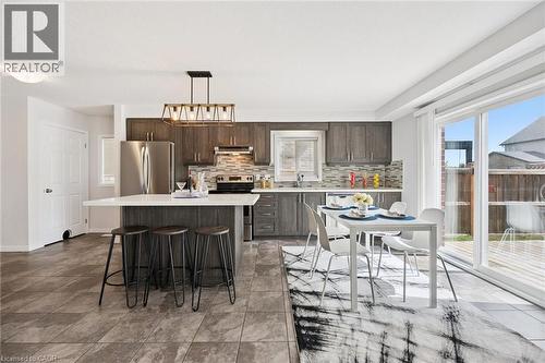 Kitchen with wood-finish cabinetry, stainless steel appliances, and an island featuring a white countertop - 360 Freure Drive, Cambridge, ON - Indoor