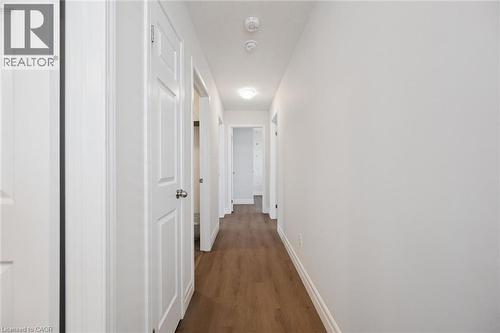 Hallway with wood-finish flooring, white panel doors, and flush-mount ceiling lighting - 360 Freure Drive, Cambridge, ON - Indoor Photo Showing Other Room