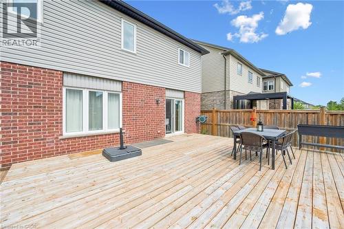 Expansive rear deck, brick exterior, sliding glass door access, white frame windows, and privacy fencing - 360 Freure Drive, Cambridge, ON - Outdoor With Deck Patio Veranda With Exterior