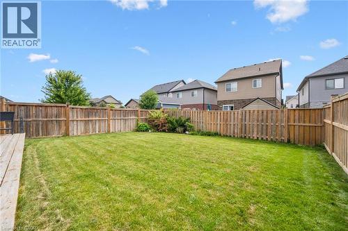 Expansive fenced backyard featuring a manicured lawn, a wooden deck, and a garden shed - 360 Freure Drive, Cambridge, ON - Outdoor