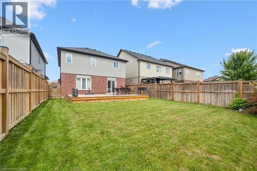 Spacious lawn with a wooden deck, full perimeter fencing, and a brick and siding exterior - 360 Freure Drive, Cambridge, ON - Outdoor With Deck Patio Veranda With Backyard With Exterior