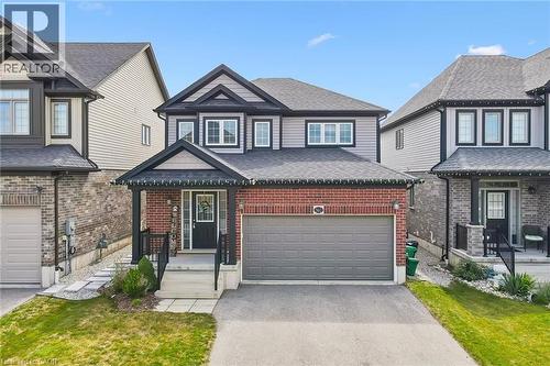 Two-story residence featuring brick and siding exterior, an integrated garage, a covered front porch, and a paved driveway - 360 Freure Drive, Cambridge, ON - Outdoor With Facade