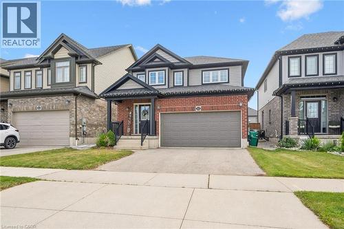 Two-story residence featuring a brick and siding exterior, an attached garage, and a covered front porch - 360 Freure Drive, Cambridge, ON - Outdoor With Facade