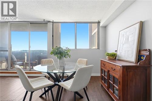 Wood-finish flooring throughout, bright interiors with large windows, and a glass-paneled sliding door opening to an outdoor space - 375 King Street N Unit# 708, Waterloo, ON - Indoor Photo Showing Dining Room