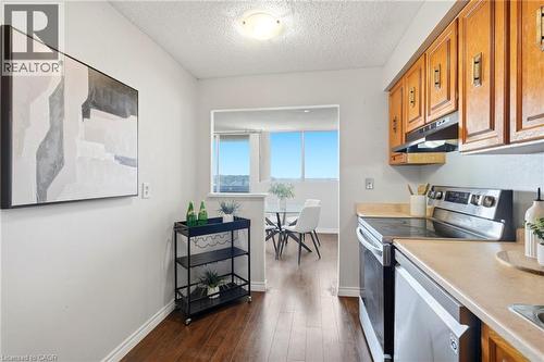 Hardwood-style flooring throughout, full kitchen with wood cabinetry, stainless steel appliances, and a pass-through window - 375 King Street N Unit# 708, Waterloo, ON - Indoor Photo Showing Kitchen