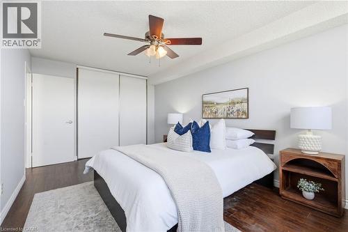 Dark wood-finish flooring with light gray wall paint - 375 King Street N Unit# 708, Waterloo, ON - Indoor Photo Showing Bedroom