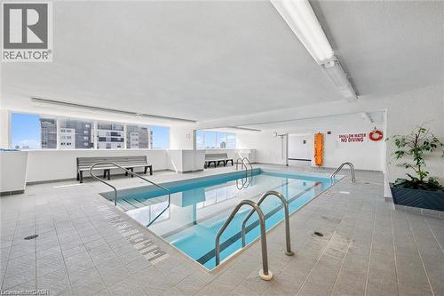 Indoor swimming pool featuring light-toned tile flooring, direct access stairs, and integrated lighting - 375 King Street N Unit# 708, Waterloo, ON - Indoor Photo Showing Other Room With In Ground Pool