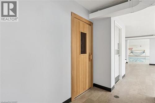 Wood-finish door with a small window, light-colored walls, and tile flooring - 375 King Street N Unit# 708, Waterloo, ON - Indoor Photo Showing Other Room
