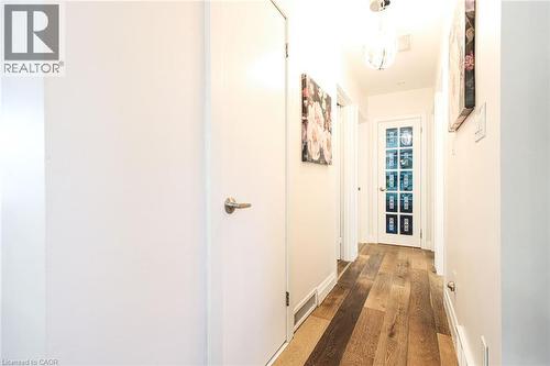 Hallway featuring wood-finish flooring, recessed lighting, white panel doors, and a glass-paneled door - 2105 Maplewood Drive, Burlington, ON - Indoor Photo Showing Other Room