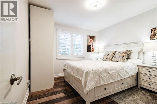 White walls with contrasting wood-finish flooring - 2105 Maplewood Drive, Burlington, ON - Indoor Photo Showing Bedroom